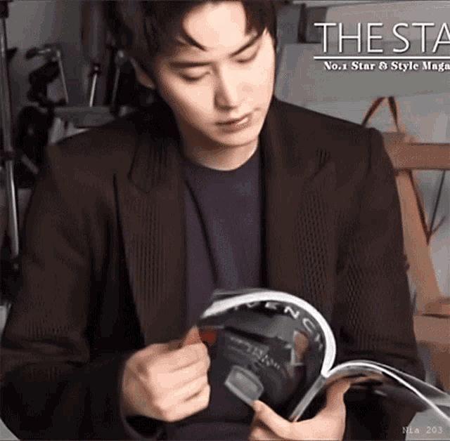a man in a suit is reading a magazine with the word thesta on it