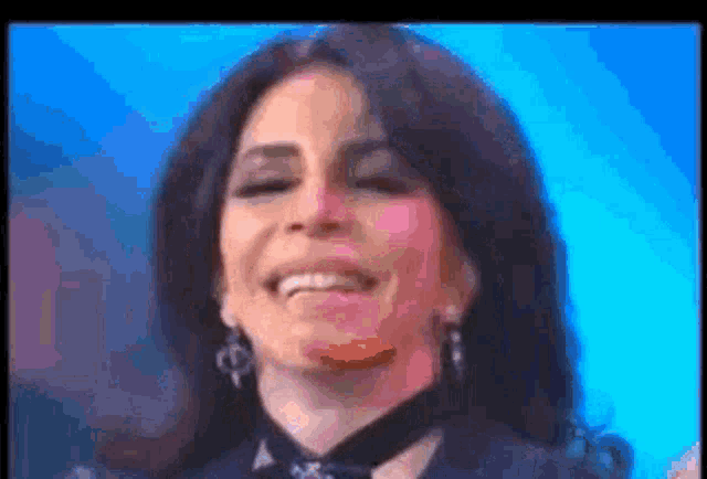 a woman is smiling and wearing a choker and earrings .