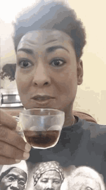 a woman is holding a cup of coffee and making a face .