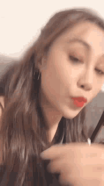a close up of a woman 's face with red lipstick on .