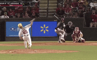a baseball game is being played in front of a walmart sign