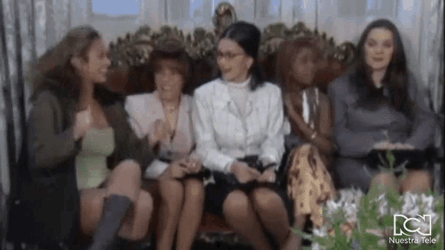 a group of women are sitting on a couch .