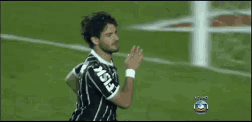 a soccer player wearing a jersey that says fg is clapping his hands