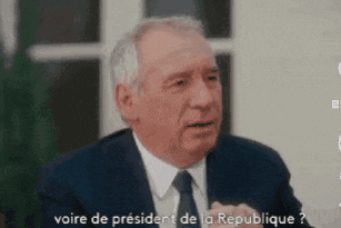 a man in a suit and tie is talking to someone in french