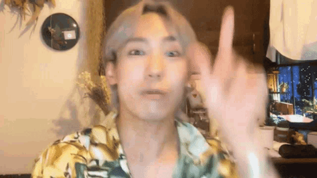a man is making a funny face while giving the middle finger .