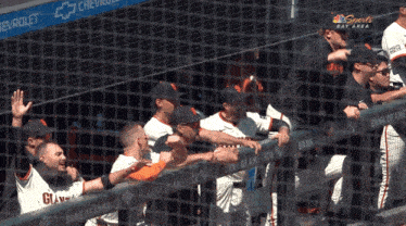 a group of baseball players behind a fence with bank of america written on it
