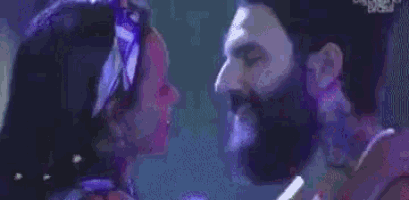 a man and a woman are kissing each other in a club .