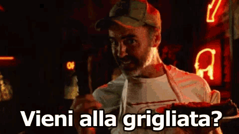 a man holding a plate of food with the words vieni alla grigliata on it