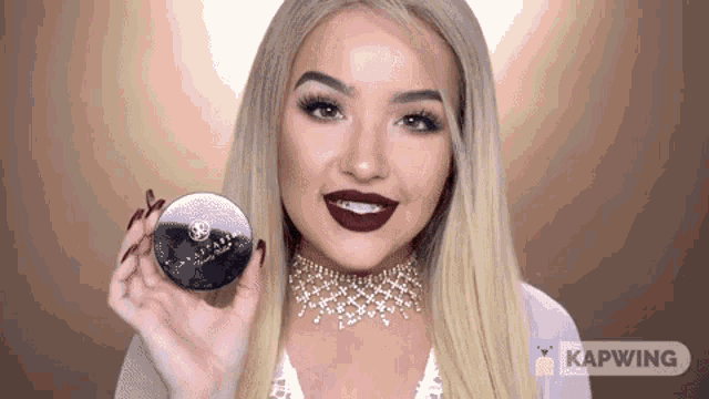 a woman wearing a choker is holding a powder in her hand and the word kapwing is on the bottom