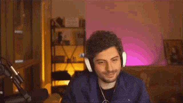 a man wearing headphones is sitting in front of a microphone .