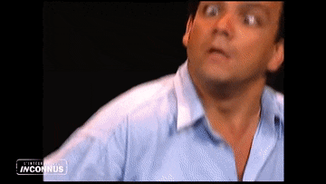 a man in a blue shirt is standing in front of a sign that says ' inconnus ' on it