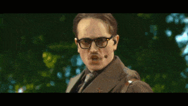 a man wearing glasses and a microphone on his mouth