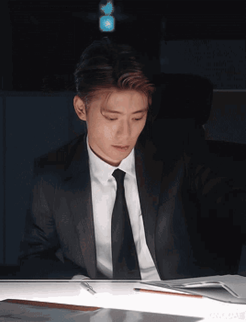 a man in a suit is sitting at a desk