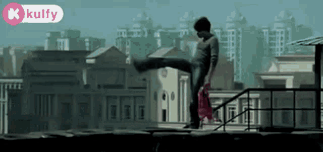 a man is doing a trick on the roof of a building with a kulfy logo in the corner