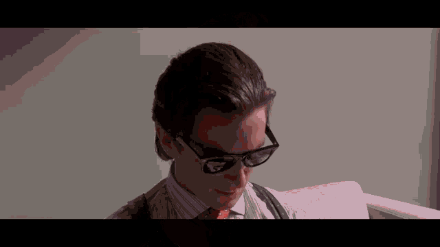 a man in a striped shirt and tie is wearing sunglasses .