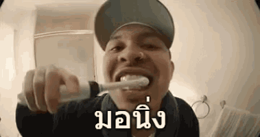 a man is brushing his teeth with an electric toothbrush .