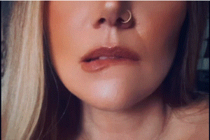 a close up of a woman 's nose with a nose ring