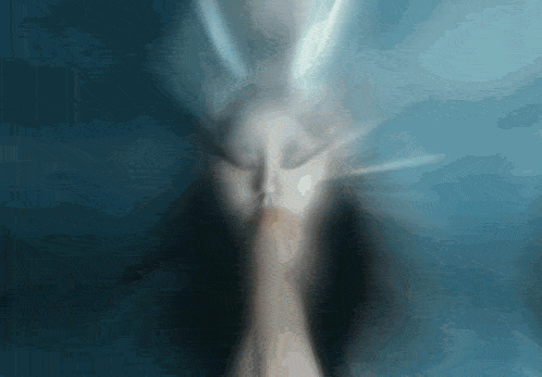 a blurred image of a person 's face with a blue background
