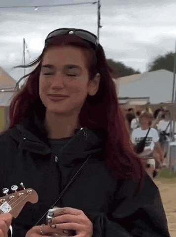 a woman with red hair is holding a guitar in her hands