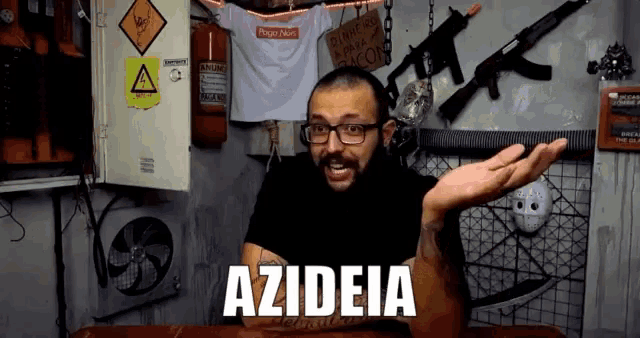 a man wearing glasses and a black shirt with the word azideia on it