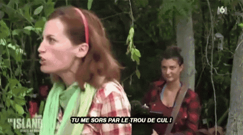 a woman in a plaid shirt is talking to another woman in a forest while another woman looks on .