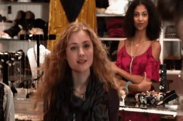 a woman with curly hair is standing in a store looking at the camera .