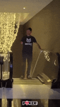 a man wearing a black shirt with the letter m on it is walking down stairs