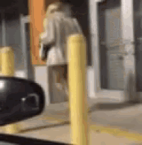 a blurry picture of a person walking in front of a building .