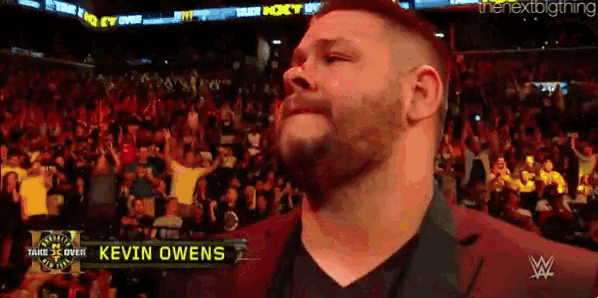 kevin owens is standing in front of a crowd of people