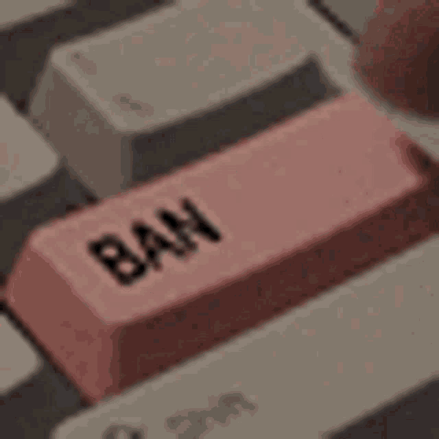 a close up of a pink ban key on a computer keyboard .