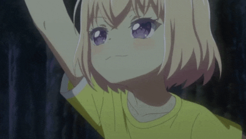 a little girl with blonde hair and purple eyes is wearing a yellow t-shirt