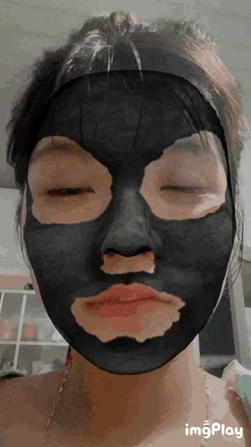 a woman with a black mask on her face has the word imgplay on the bottom right