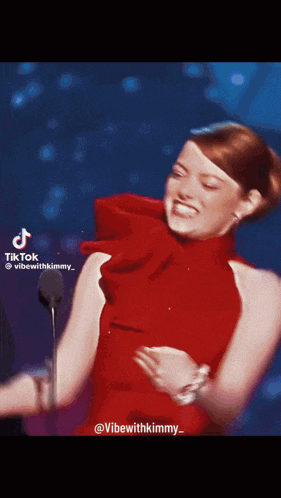a woman in a red dress is dancing on a stage