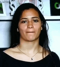 a close up of a woman wearing a necklace and a black shirt .