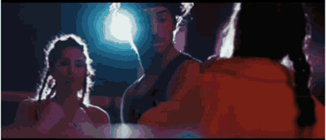 a man and two women are dancing in a dark room