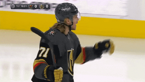 a hockey player with the number 71 on his jersey stands on the ice