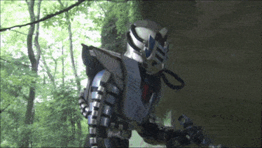 a man in a robot costume is standing in the woods holding a sword
