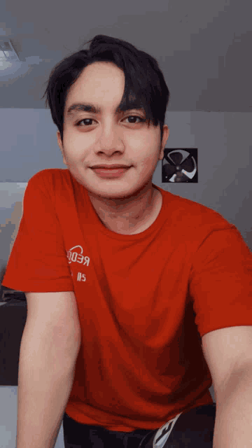 a man wearing a red t-shirt that says ' 003a ' on it