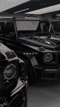two black cars are parked next to each other and the word money is on the side