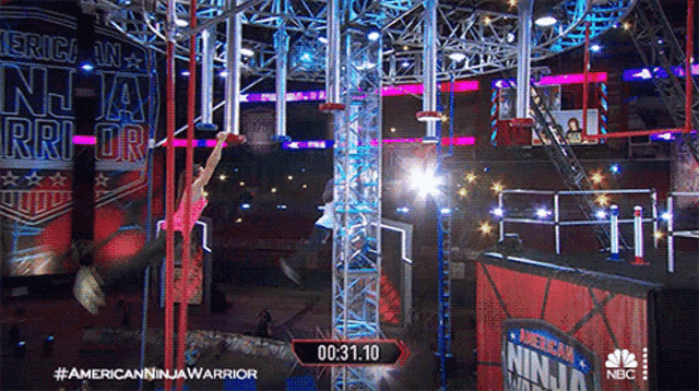 a person is climbing a rope in a ninja warrior competition
