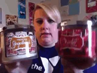 a woman is holding a jar of gingerbread candy