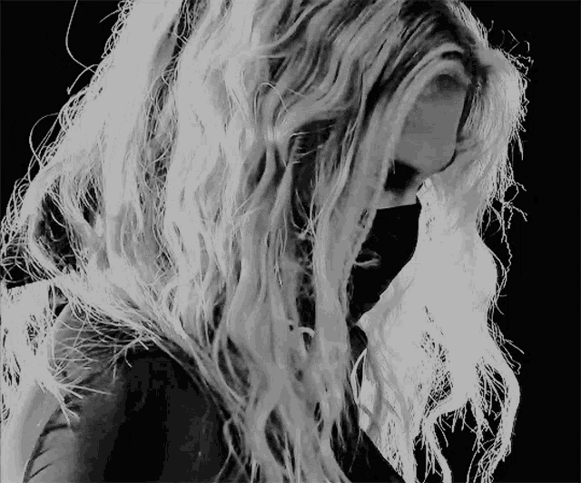 a black and white photo of a woman 's face and hair