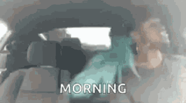 a person is sitting in the back seat of a car with the words morning written on the screen .