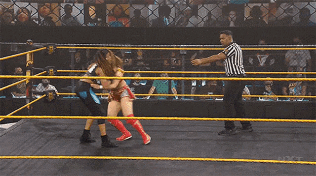 two women are wrestling in a ring with the word nxt on the bottom