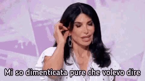 a woman is talking in a foreign language and holding her hair .