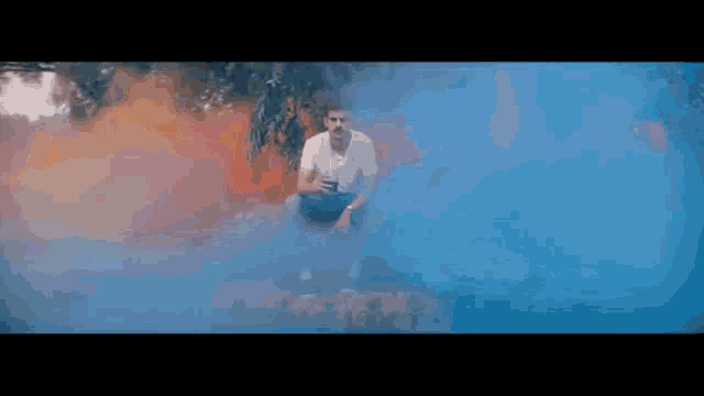a man is sitting on a rock surrounded by blue smoke