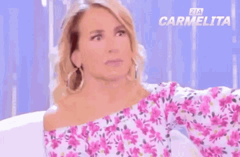 a woman sitting on a couch with the words non lo voglio sapere
