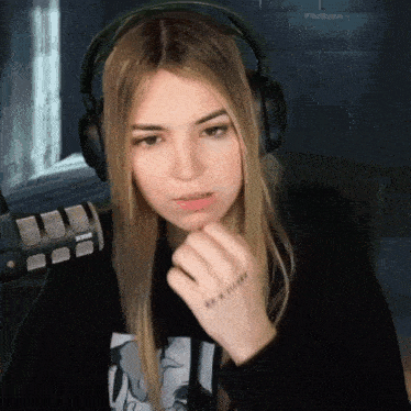 a woman wearing headphones and a microphone has a tattoo on her wrist that says ' i love you '