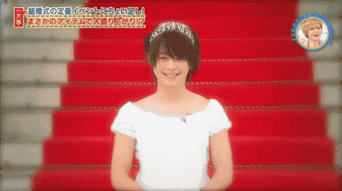a woman in a white dress is standing on a red carpet in front of a staircase