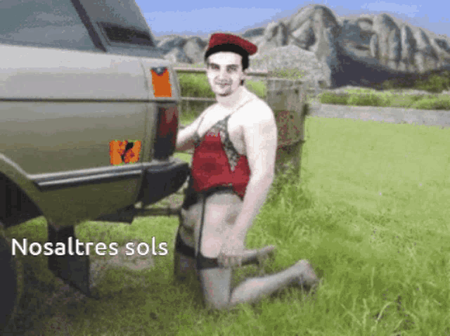 a man is kneeling in front of a car with the word nosaltres sols written below him